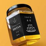 A mockup of a jar of tofu with the words 'Experience Jintan' and 'Tofu on it' Various words are written on it in Mandarin.