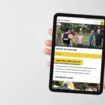A photo of an iPad being held with the fiftyfitness website on it.